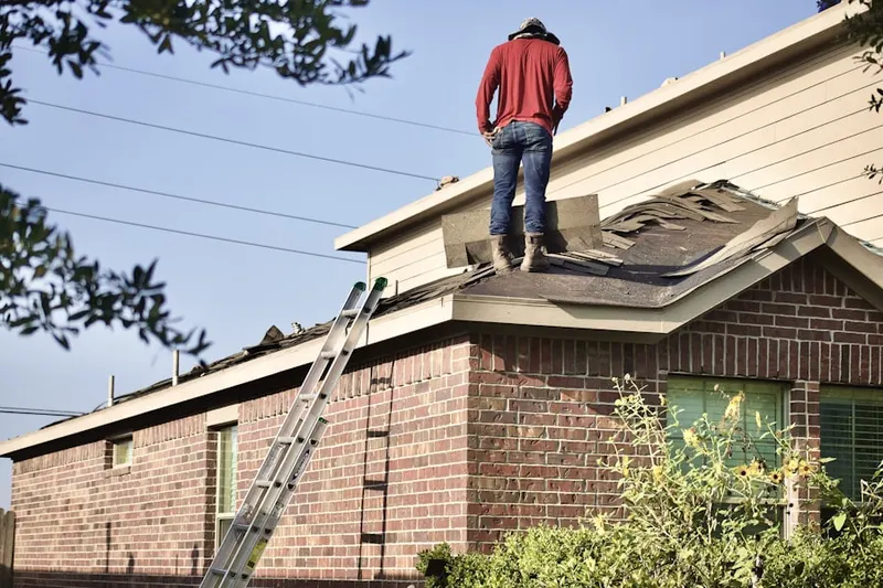 Professional roofer working on a residential roof in Rombury Oaks